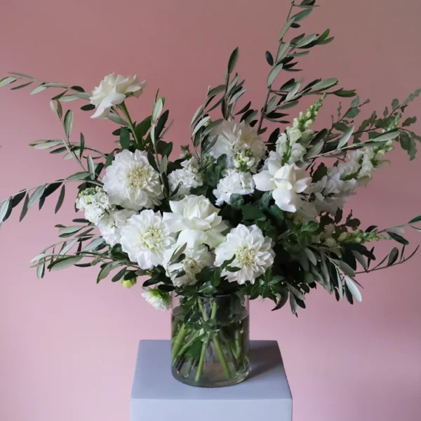 modern, white and green vase of flowers with olive foliage, reflexed roses, dahlias and snap dragons.