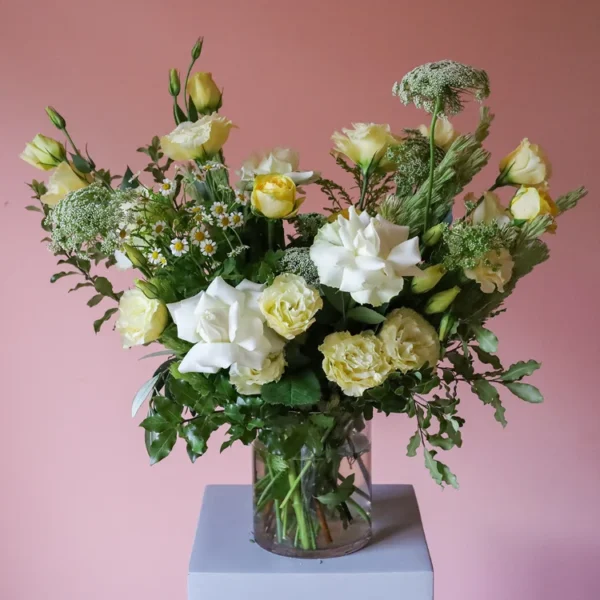 Vase of flowers with buttery yellow and white flowers