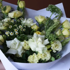 Vase of flowers with buttery yellow and white flowers