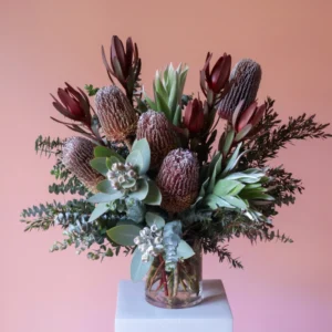 Australian native flower arrangment in vase with banksias, gum nuts and leucadendron.