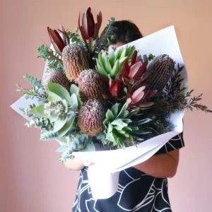 Australian native flower arrangment in vase with banksias, gum nuts and leucadendron.