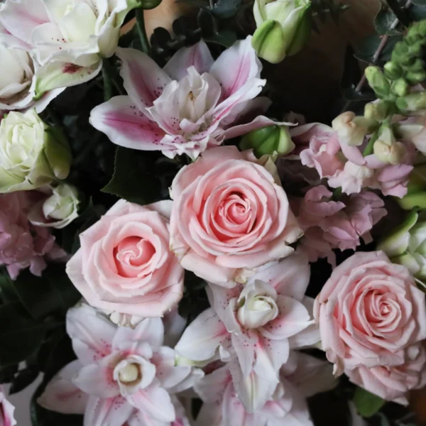 Close-up of pastel pink flowers including roses and rose lilies.