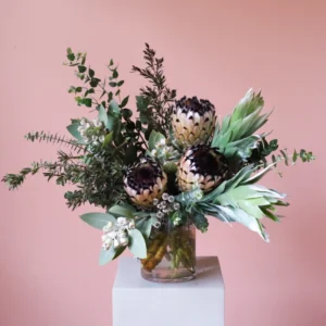 Vase arrangement of native flowers including queen proteas and tetragona gumnuts.